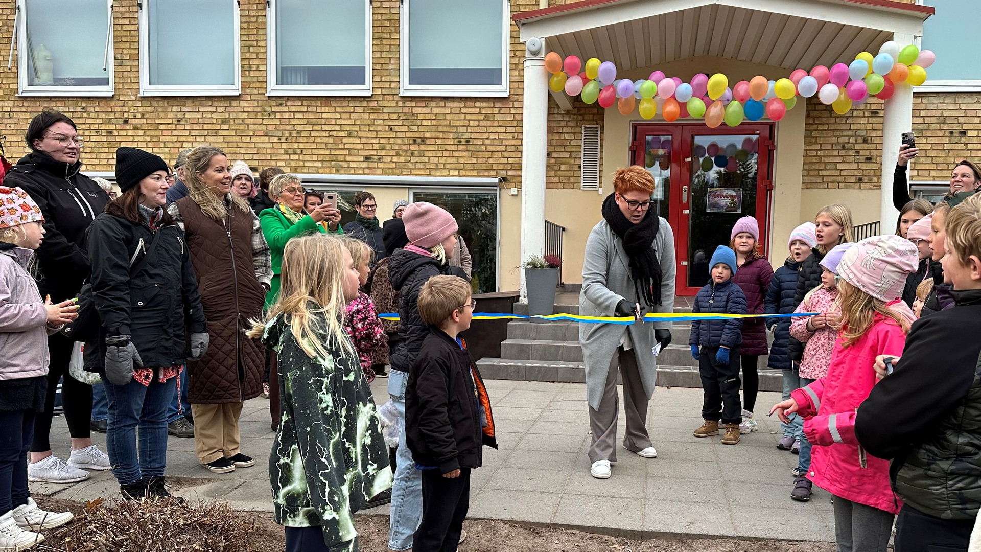 Rektor Silva Carlstein klipper bandet vid invigningen av Fågelås skolas nya skolgård.
