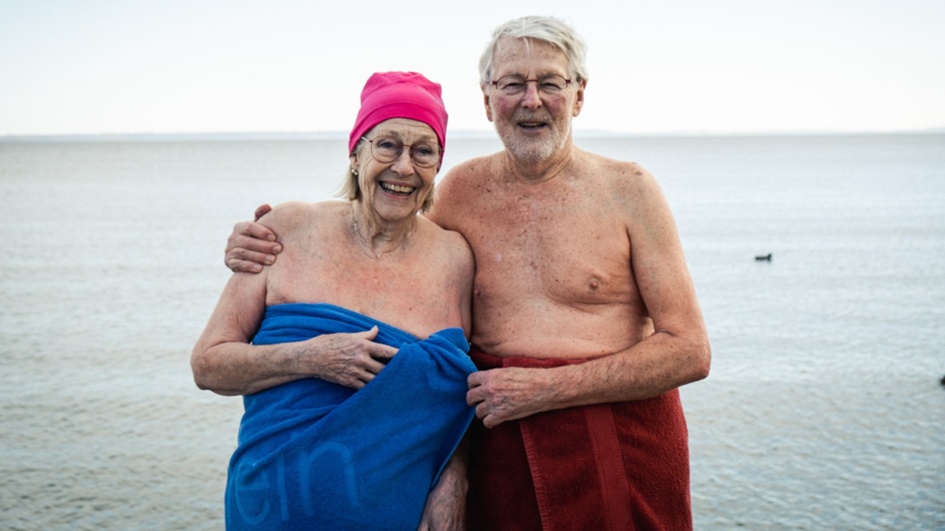 Ett äldre par ler in i kameran efter ett vinterbad i Vättern.