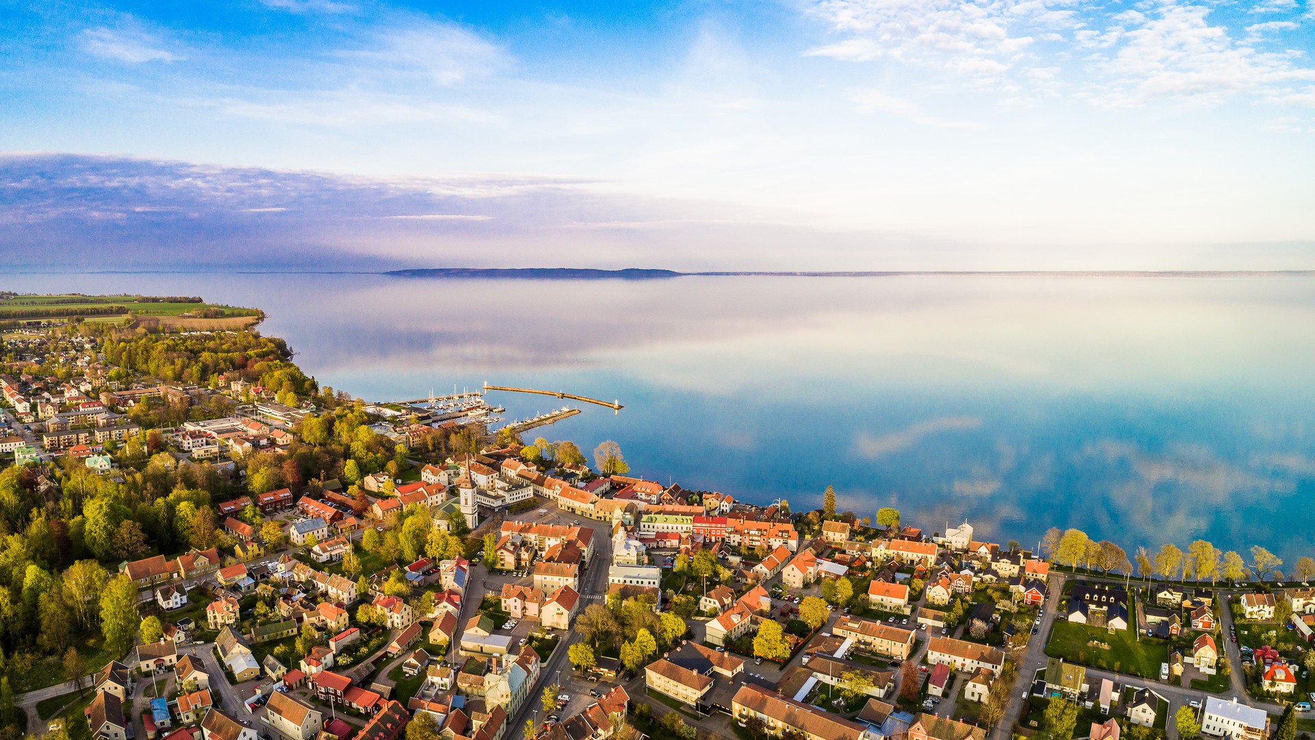 Flygbild med vy över Hjo stad, hamnen och Vättern.