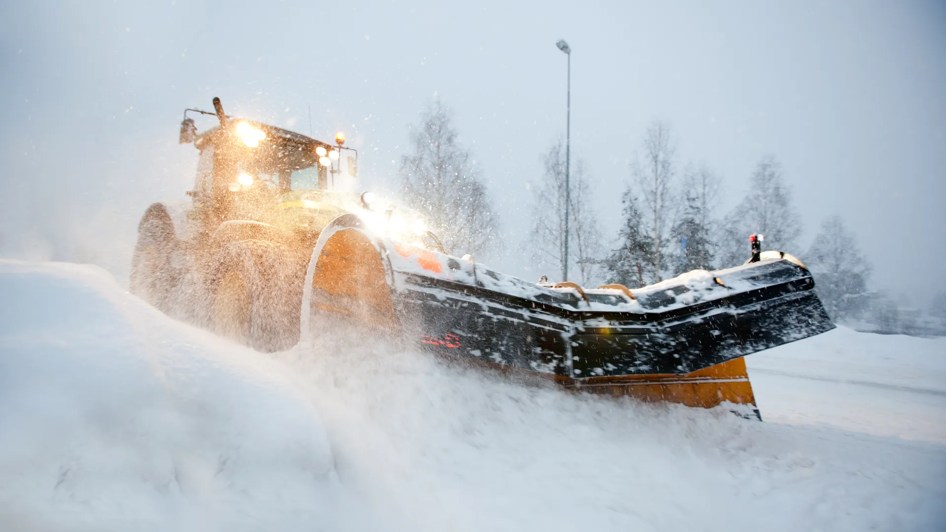 A snow plow clearing a road in winter