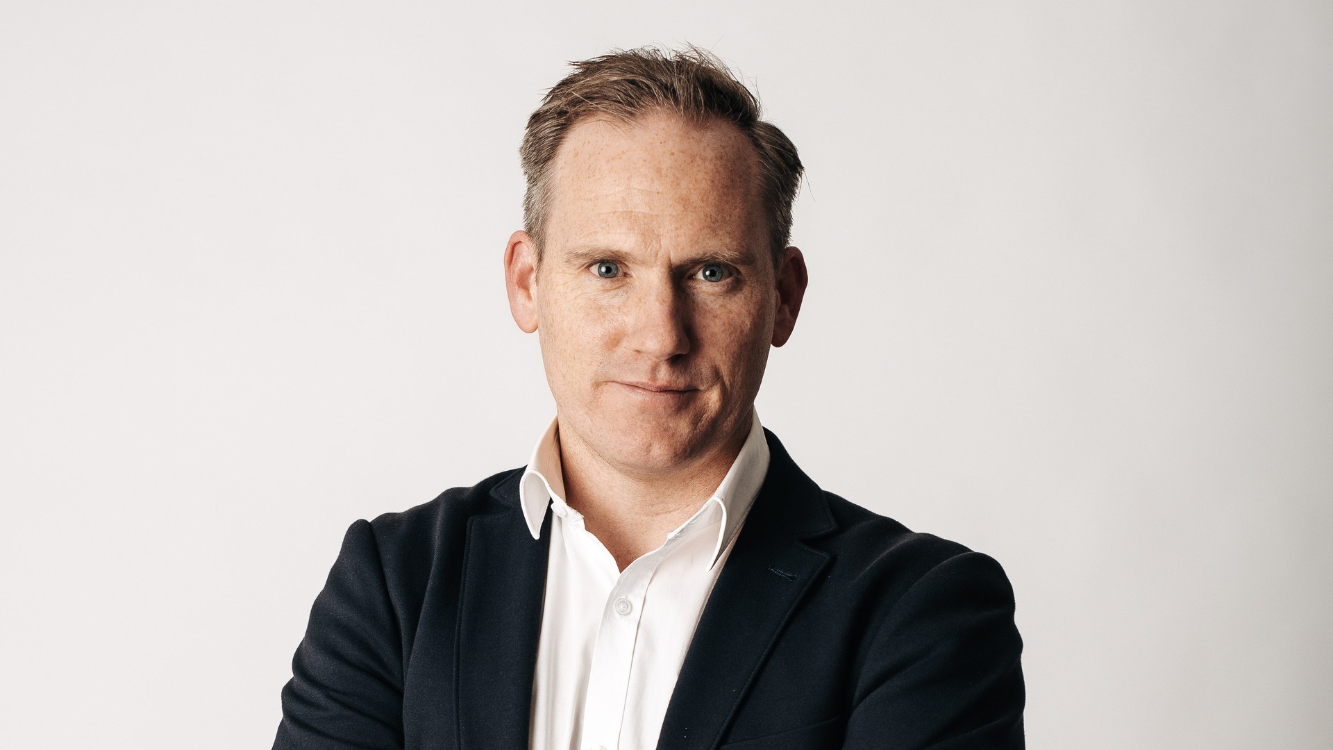 Christian sitter med korsade armar