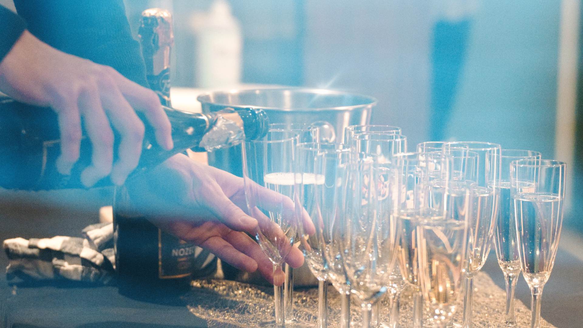 Någon häller upp dryck i champagneglas