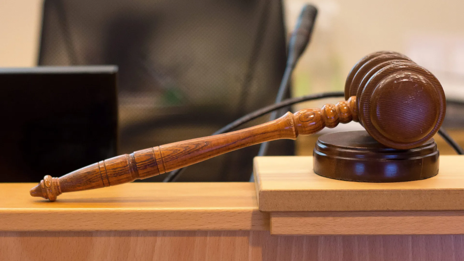 En beslutsklubba på ett bord, samt texten "Hjo kommunfullmäktige".