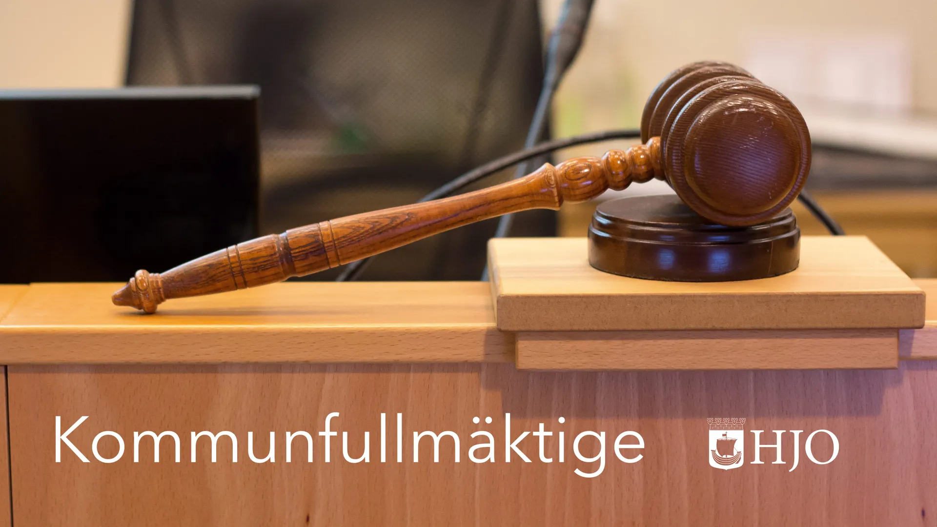 Beslutsklubba och texten "Kommunfullmäktige Hjo"