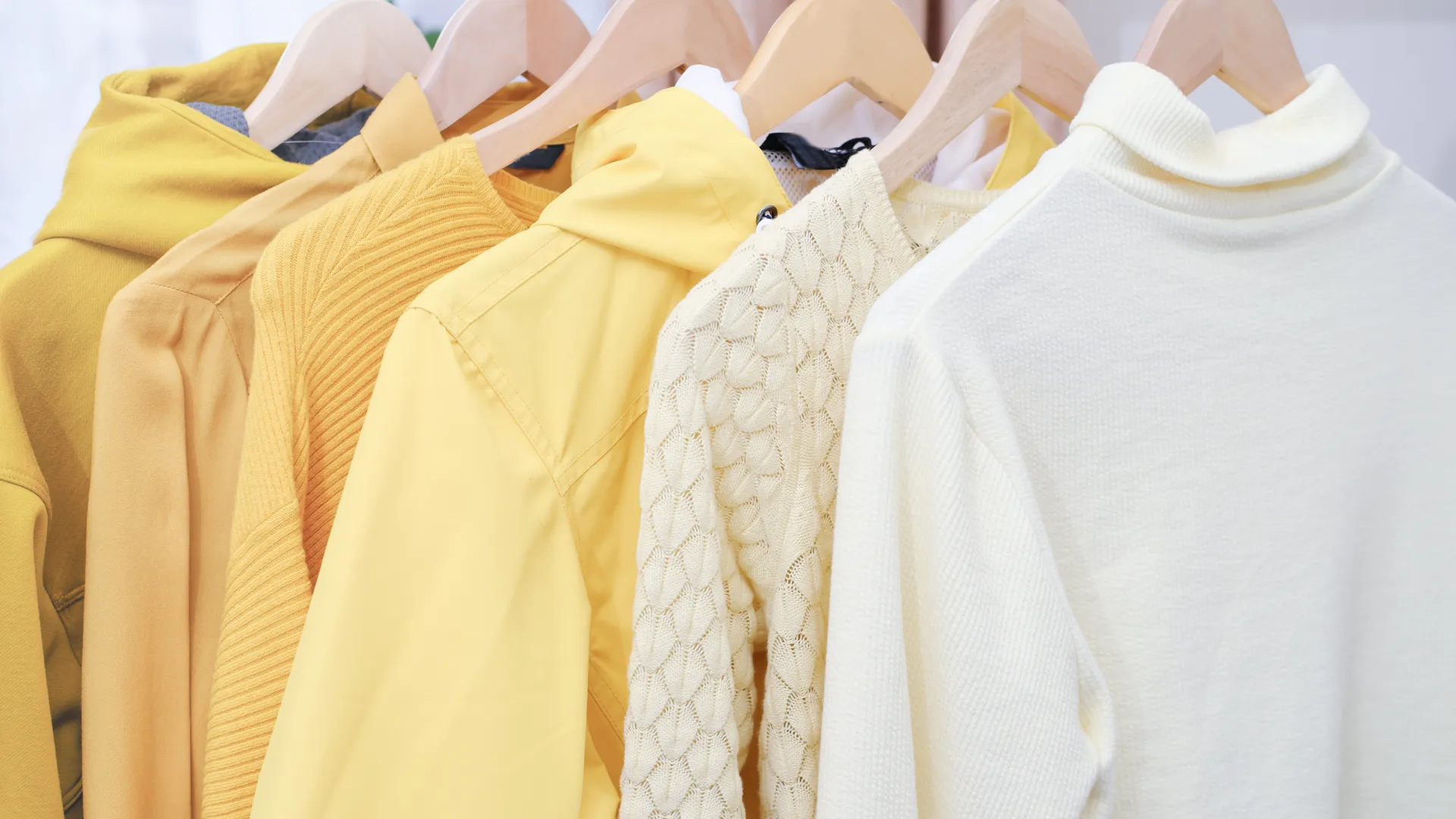 Kläder på en hängare i en gul skala från ljus till mörk gul.