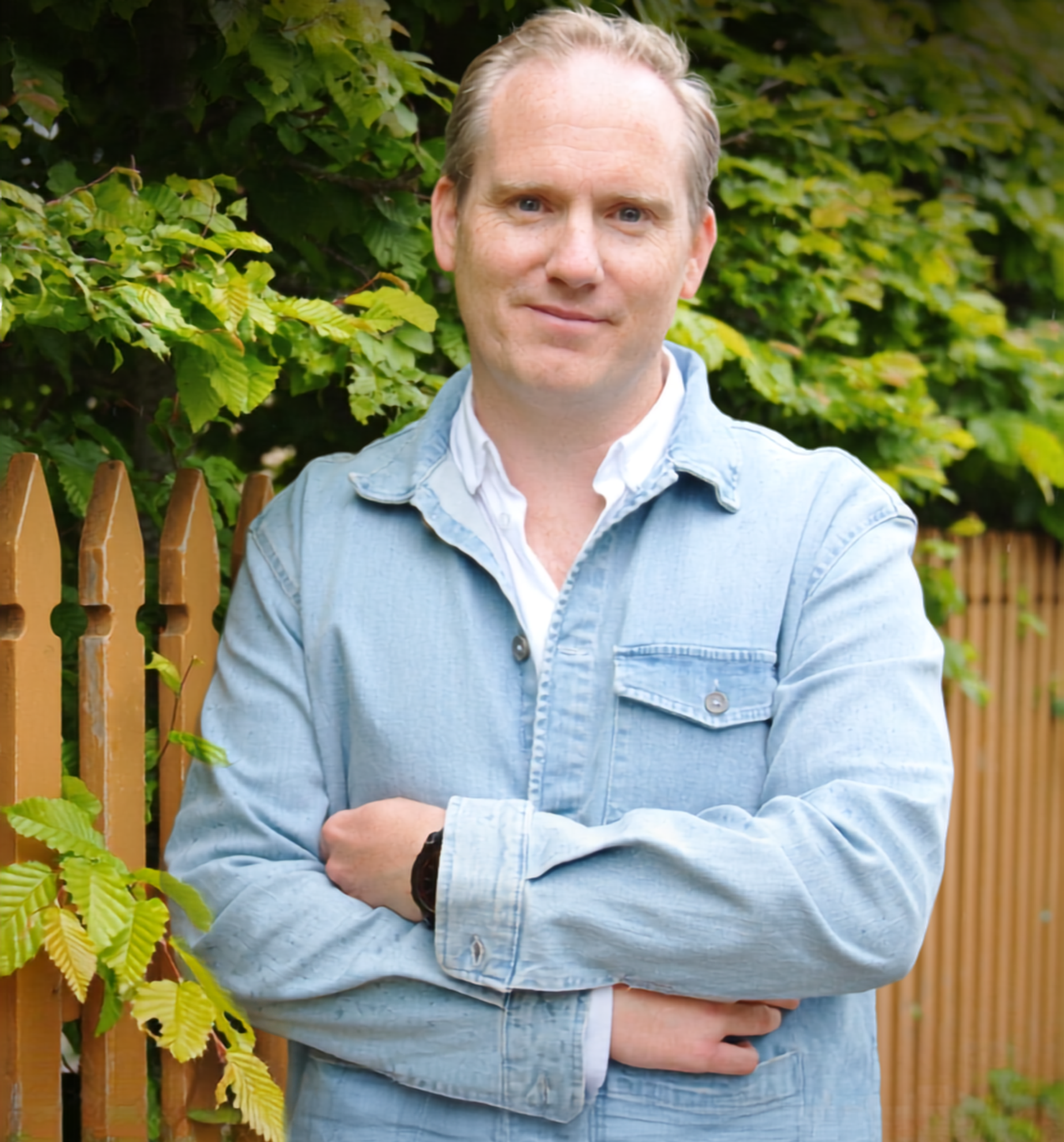 Christian står framför ett trästaket.