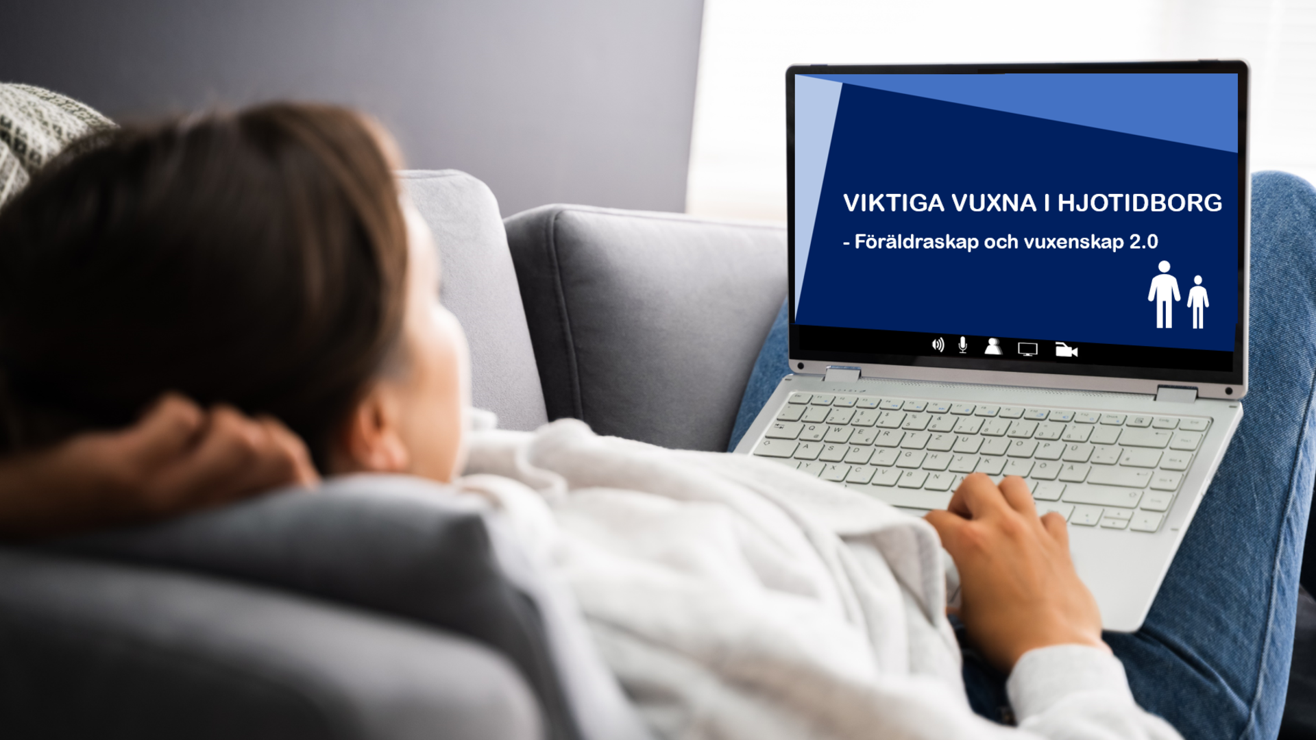 Kvinna ligger i soffan med en laptop och kollar på Viktiga vuxna i HjotTidBorg