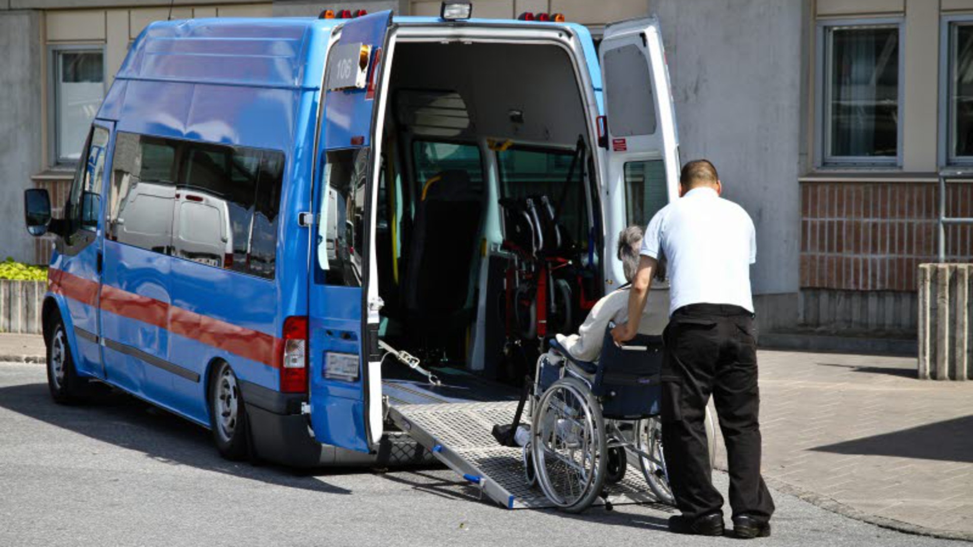 En person i rullstol rullas in i en färdtjänstbuss.