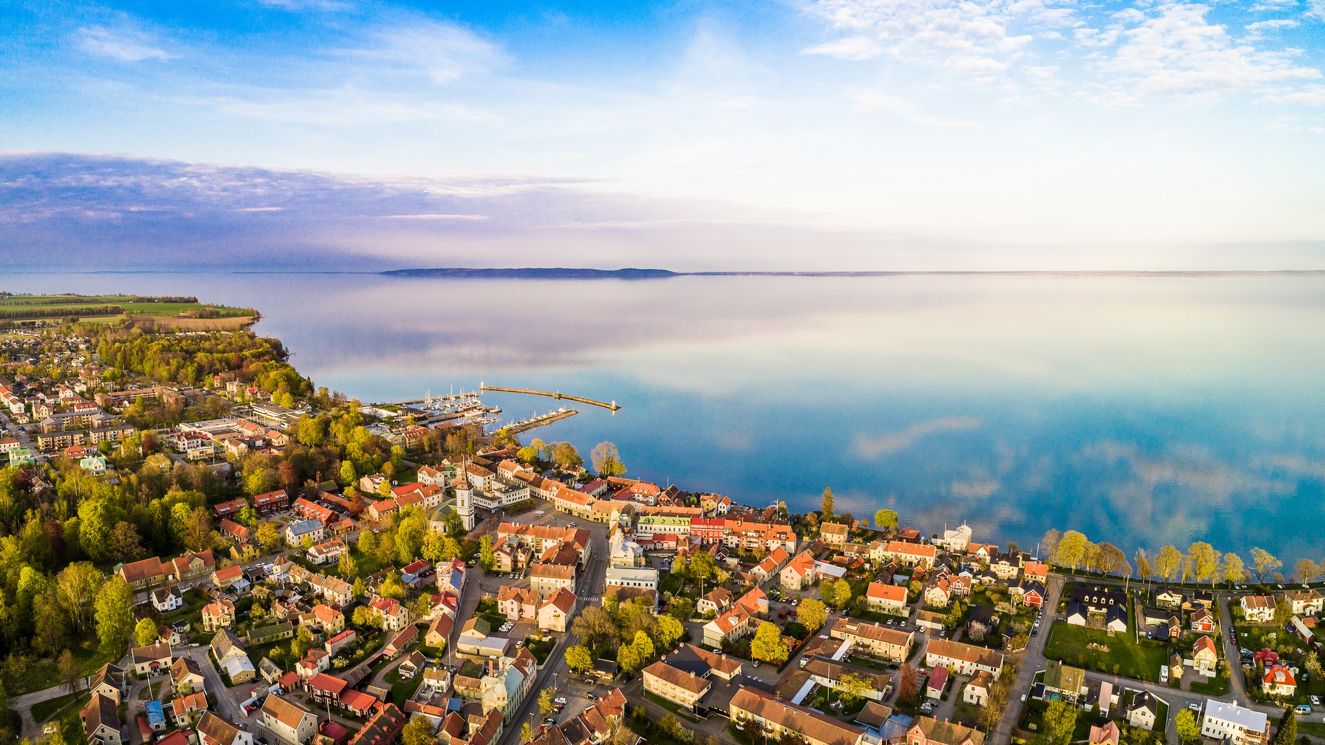 Flygbild med vy över Hjo stad, hamnen och Vättern.