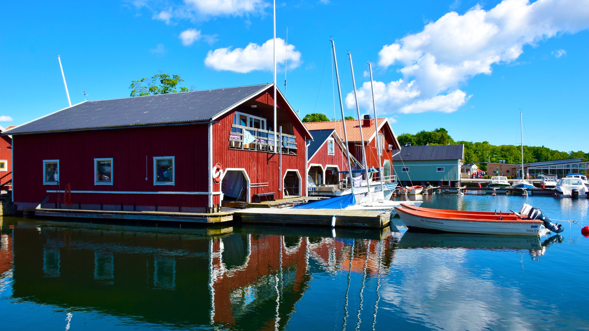 Bild från vattnet som visar Hjo hamn en solig sommardag.