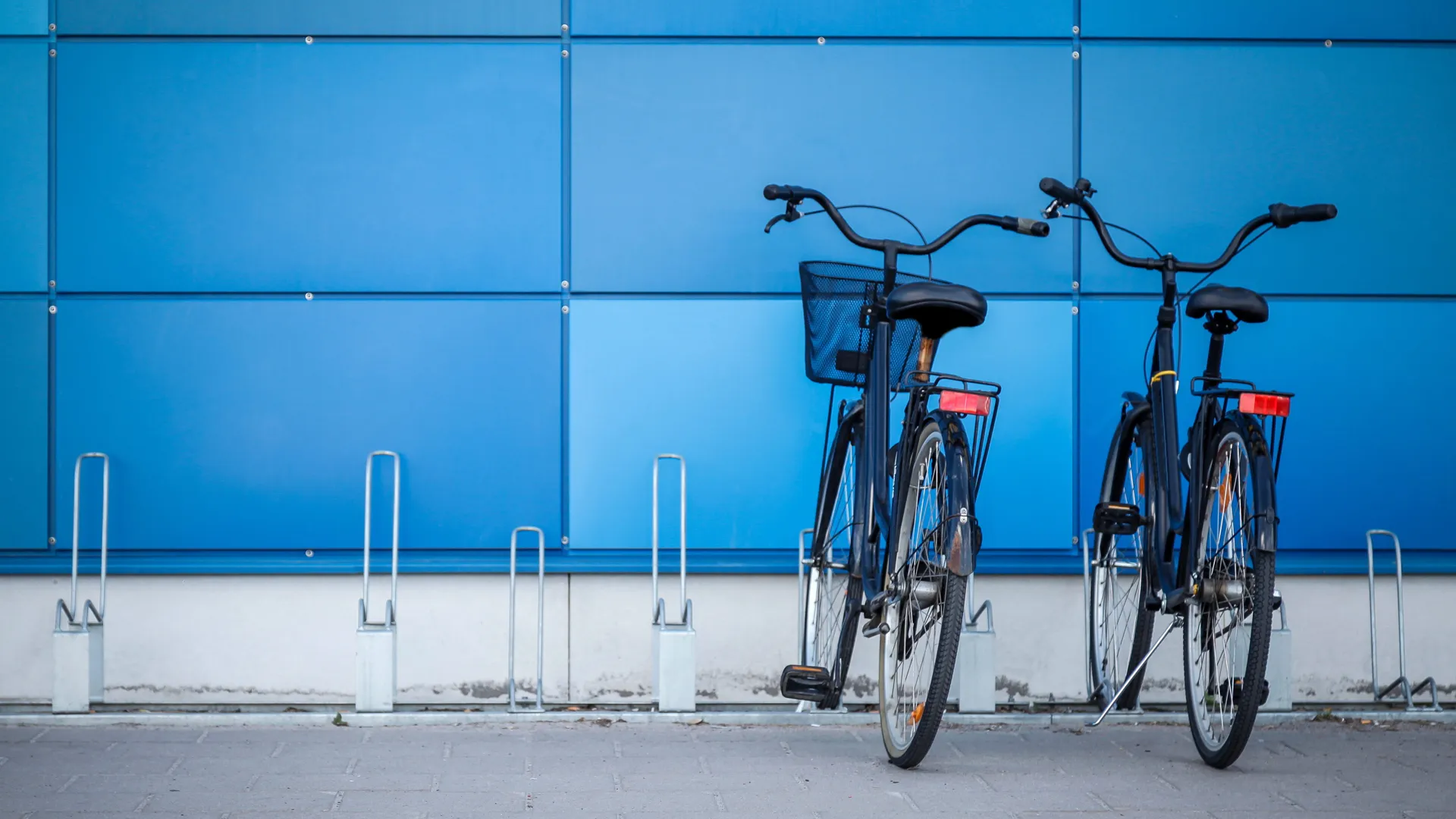 Två cyklar parkerade i ett cykelställ.
