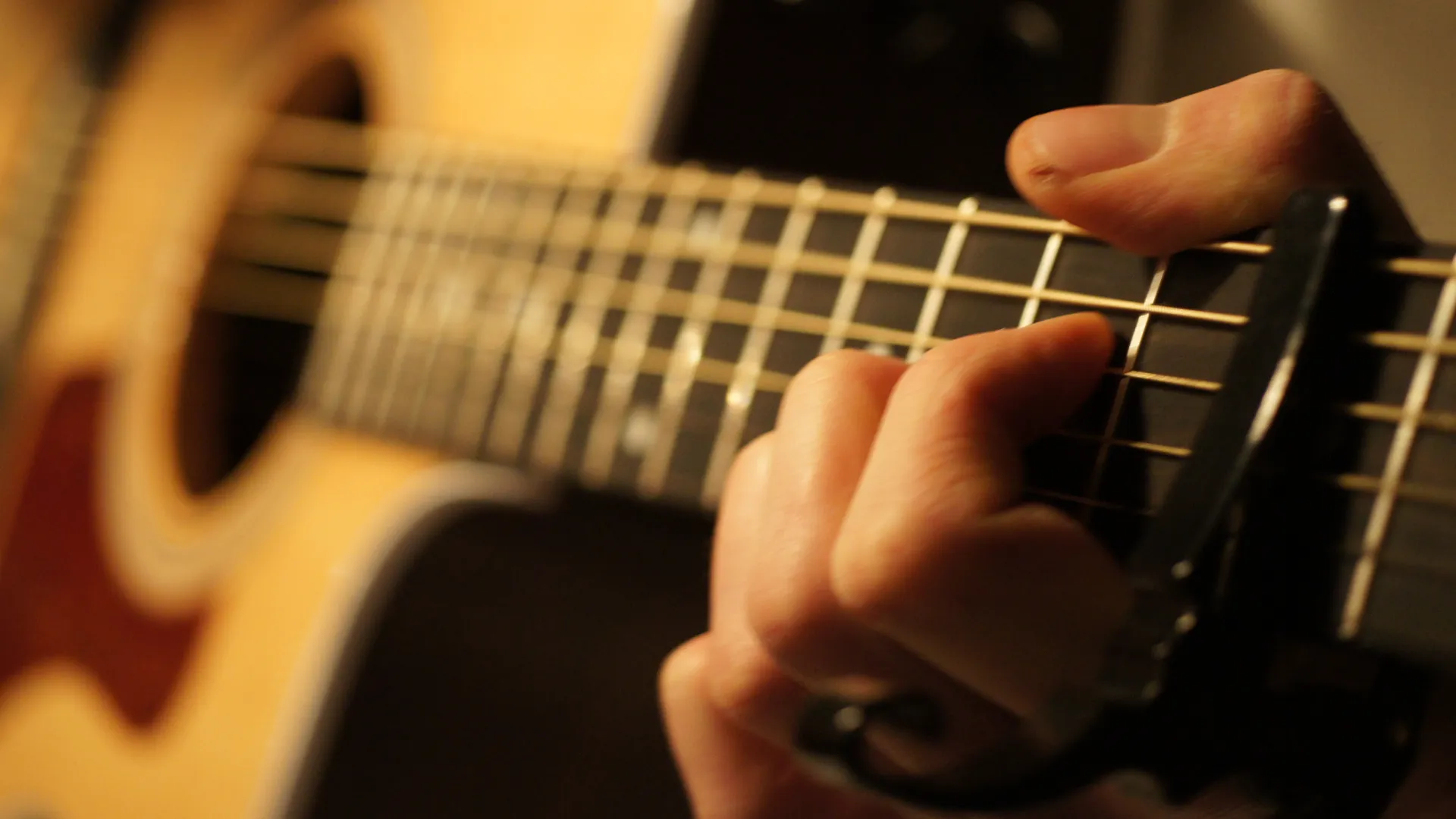 Närbild på en person som spelar gitarr