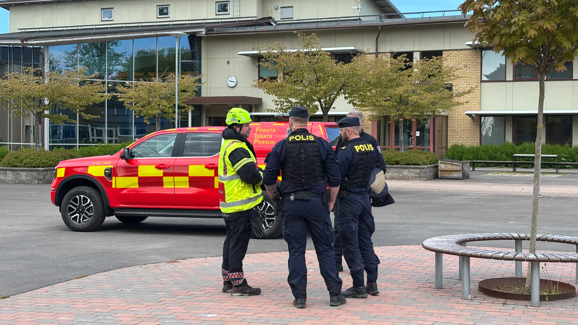 Blåljuspersonal och en bil från räddningstjänsten framför Guldkroksskolan.