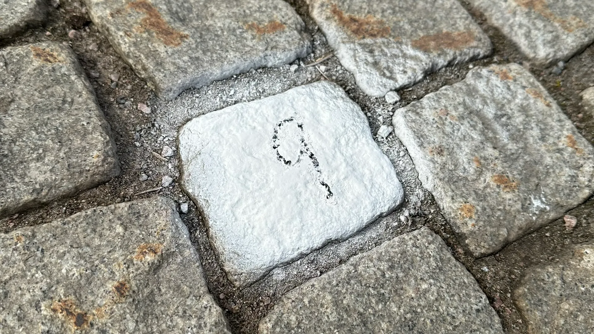 En vit fyrkant på en kullerstensgata.