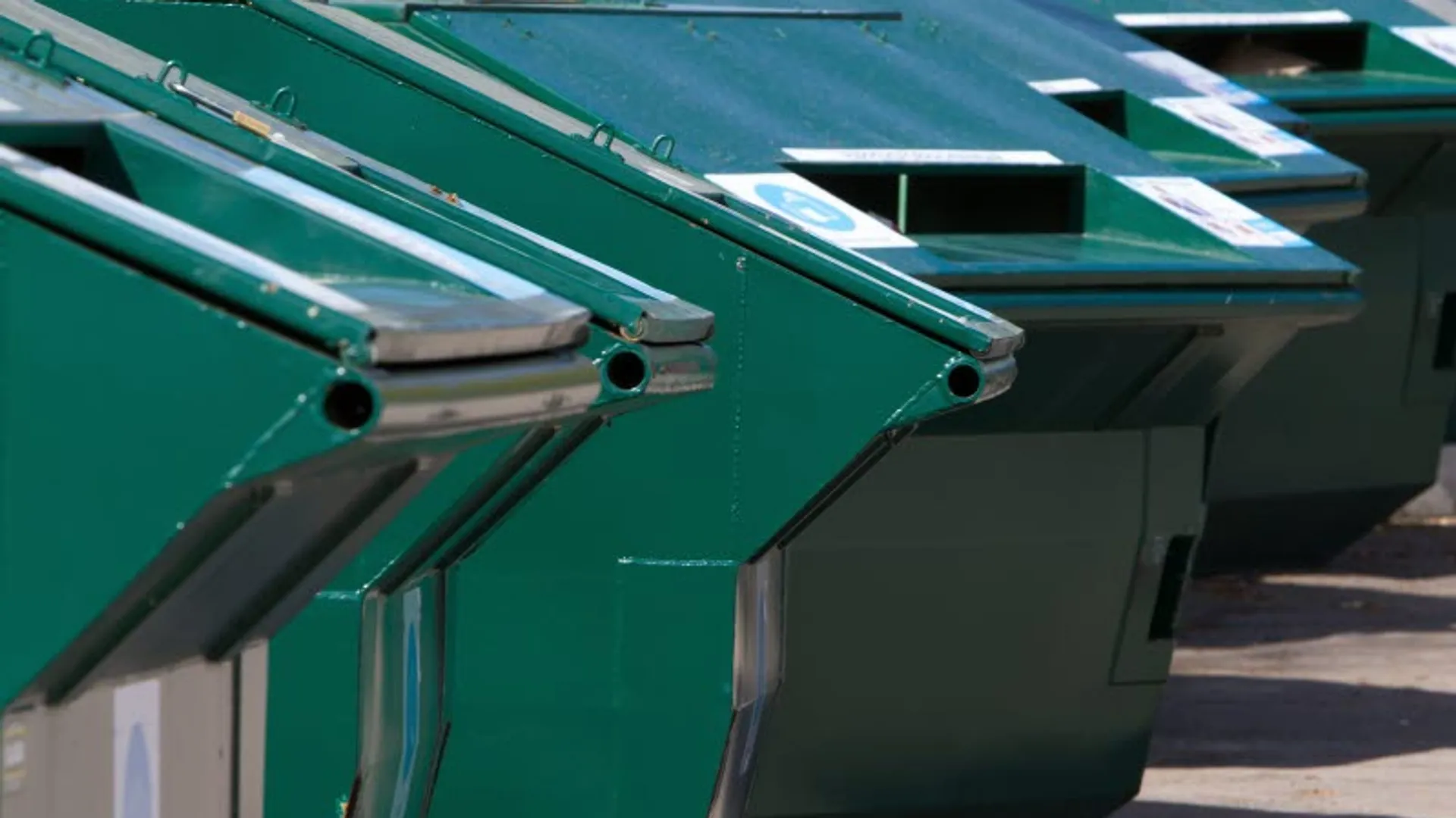 Gröna containrar på en återvinningsstation.