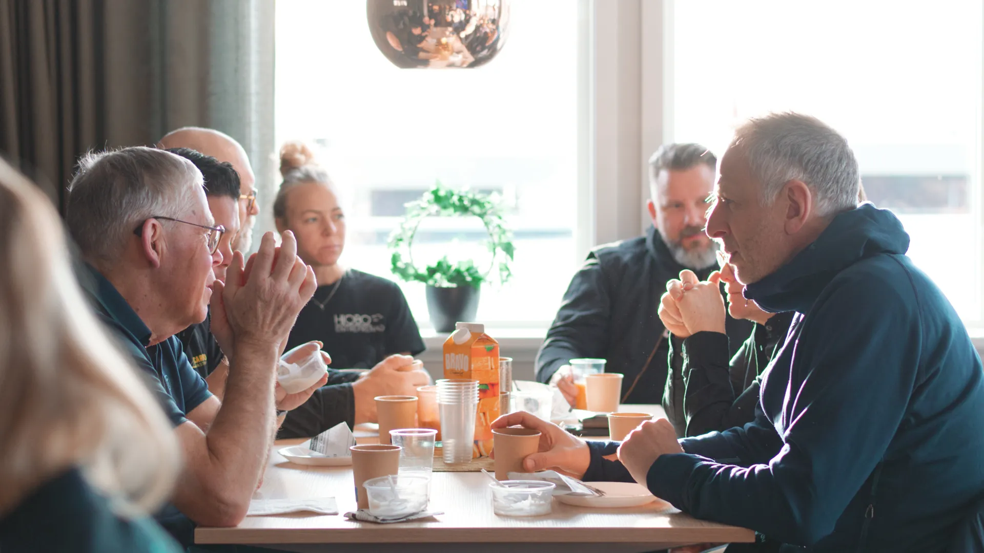 En grupp människor som sitter runt ett bord och äter mat.