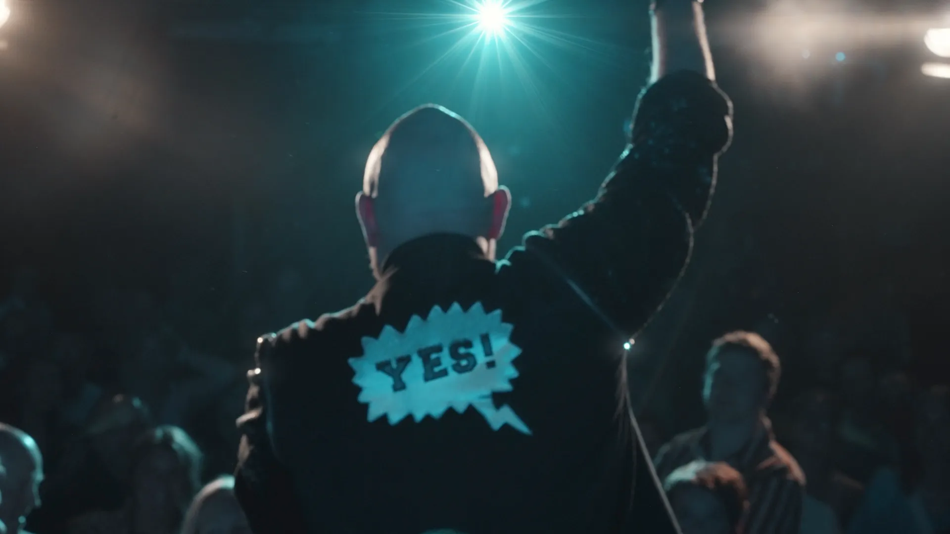 En man står framför en folkmassa på en konsert.