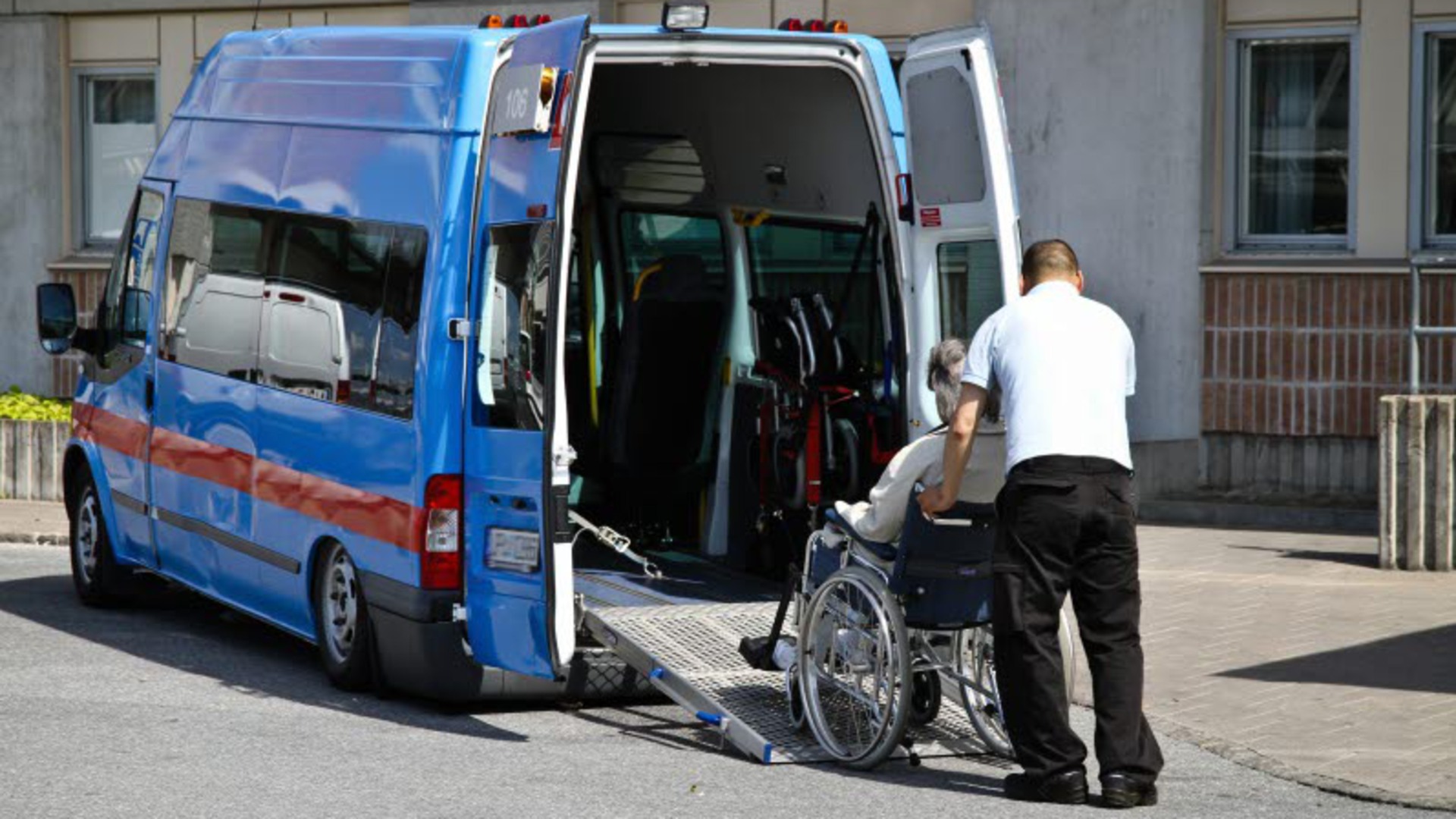 En person i rullstol rullas in i en färdtjänstbuss.