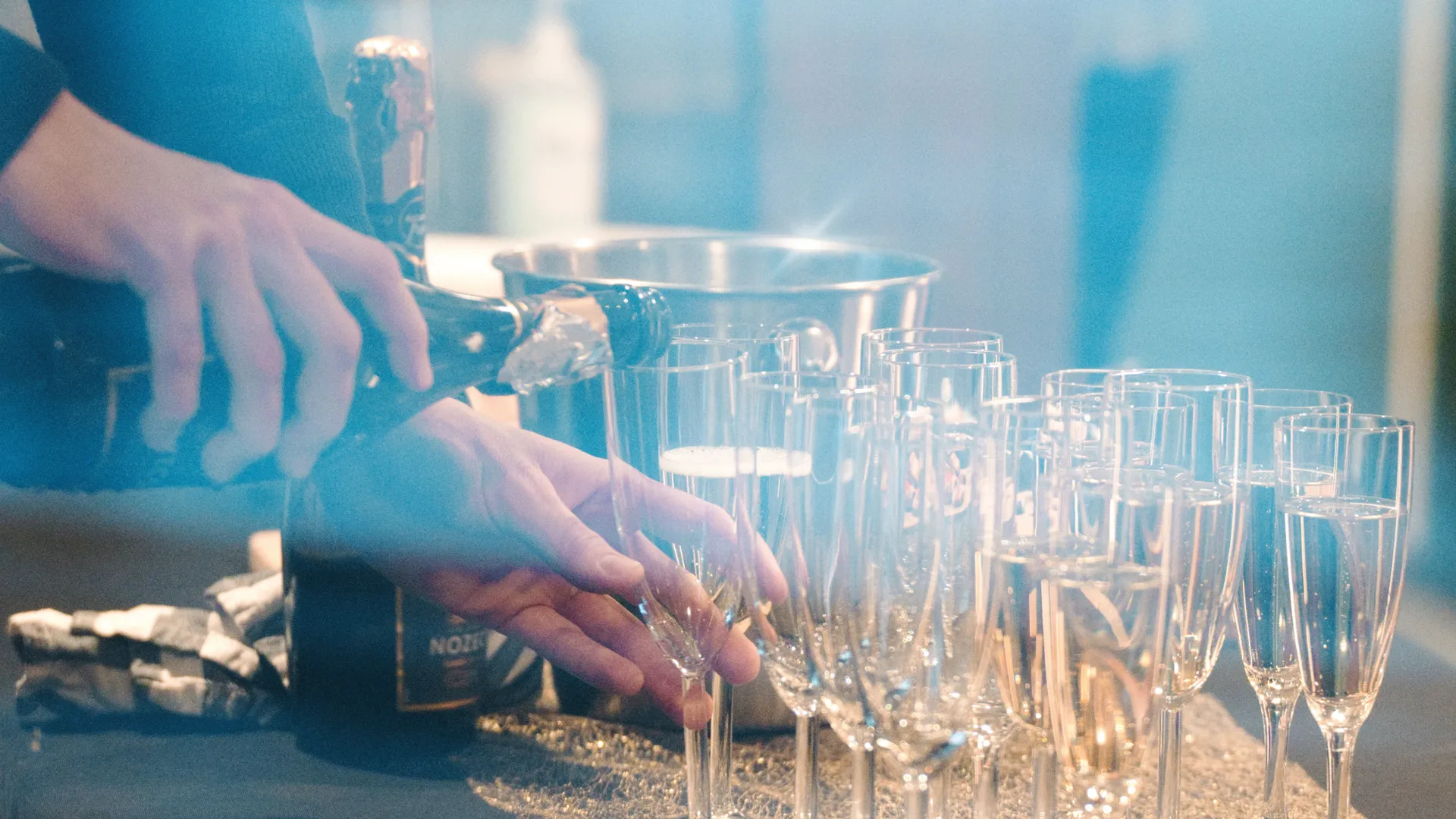 Någon häller upp dryck i champagneglas