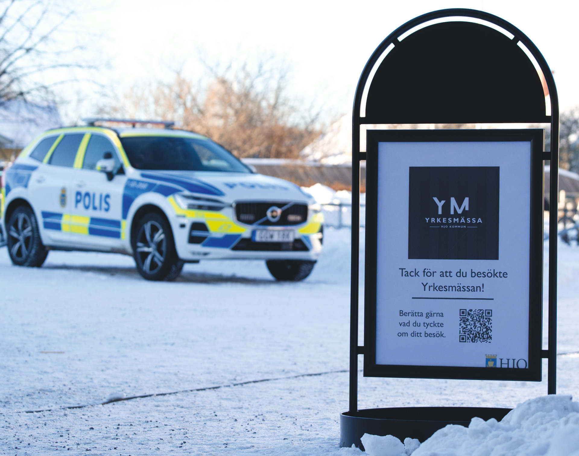 En polisbil parkerad bredvid en trottoarpratare i snön.