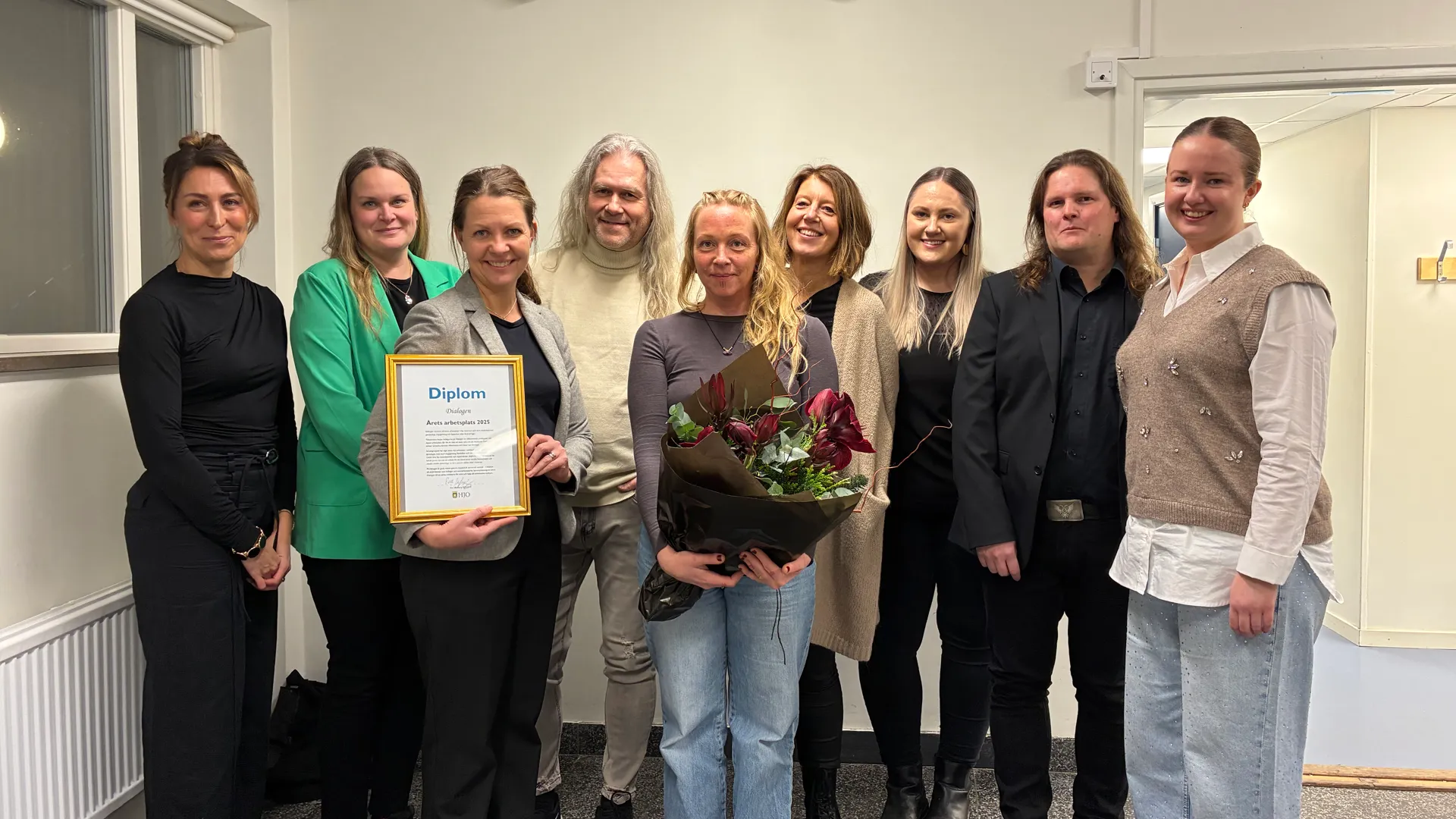 Gruppbild av personal på Dialogen, med diplom och blommor.
