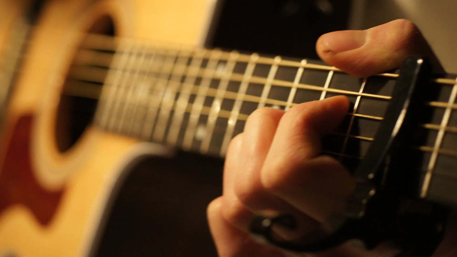 Närbild på en person som spelar gitarr