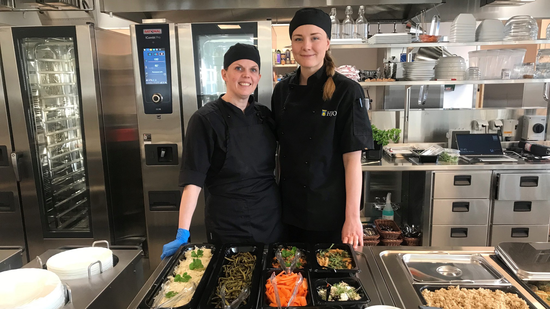 Två kockar visar upp dagens lunch i skolan.